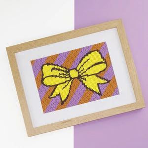 Kit canevas Noeud avec toile, fils coton et aiguille pour débutants, motif nœud jaune sur fond rayé moderne.