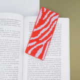 Kit canevas moderne marque-page Zebre réalisé au demi-point de canevas et présenté dans un livre