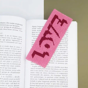Kit canevas marque-page Love bicolore réalisé et présenté dans un livre
