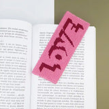 Kit canevas marque-page Love bicolore réalisé et présenté dans un livre