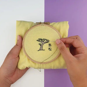 Réalisation sur un tee shirt jaune du kit de broderie pin japonais au motif de bonsaï.