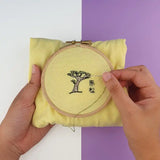 Réalisation sur un tee shirt jaune du kit de broderie pin japonais au motif de bonsaï.