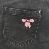 Kit de broderie Noeud rose réalisé sur un jean noir
